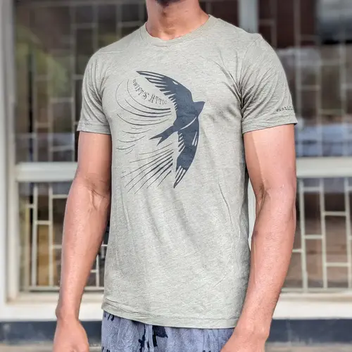 A man wearing a light green t-shirt with a bird graphic design.