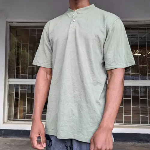 A young man wearing a casual olive green short-sleeve tee.