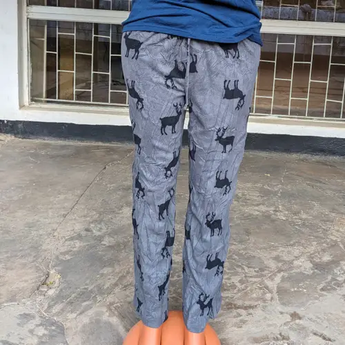 A mannequin wearing a blue t-shirt and gray pajama pants with animal prints.