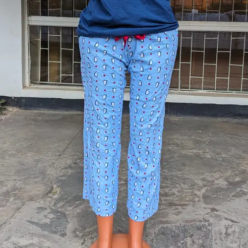 A woman wearing a blue pajama set with playful patterns.