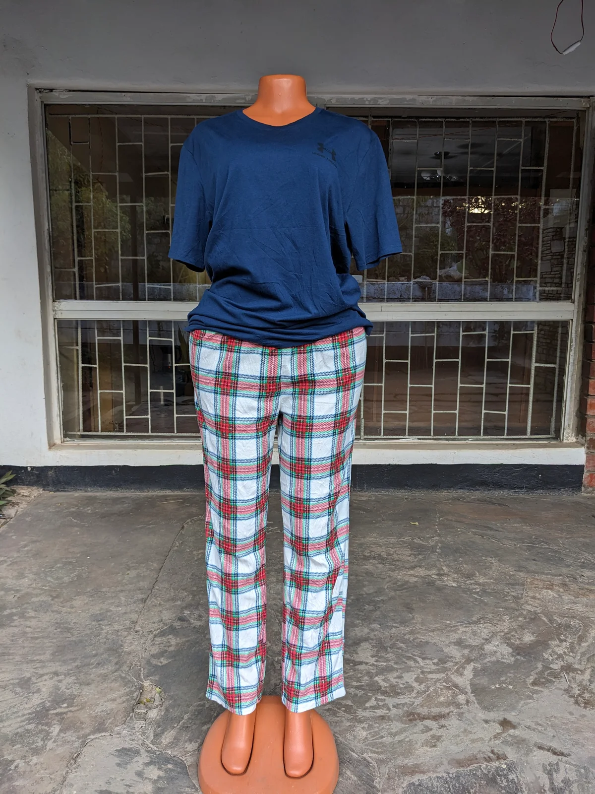 A mannequin displaying a navy blue top and plaid lounge pants.