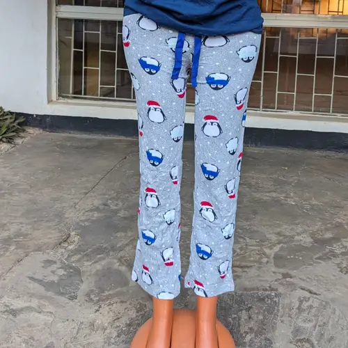 A cozy pajama set with penguin prints, featuring a blue top and gray pants.